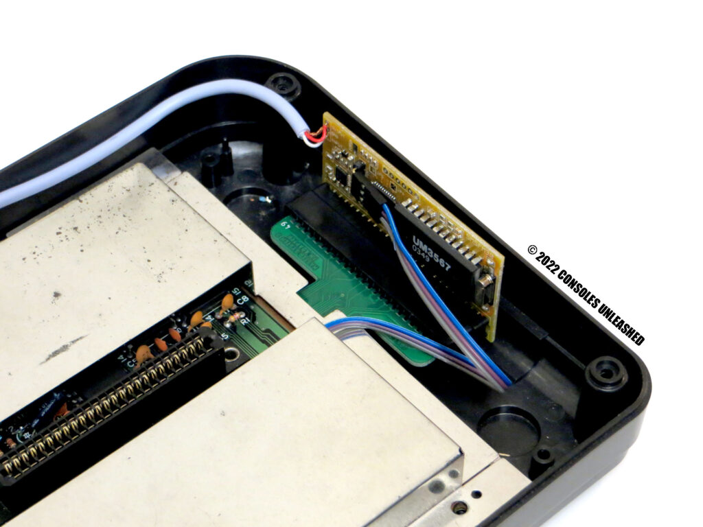 Top side of Sega Master System 2 FM Sound Module Adapter installed with attached FM Module. Shown in Master System bottom case with RF shield on.