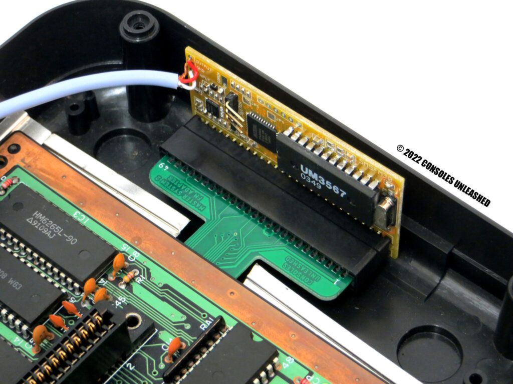 Top side of Sega Master System 2 FM Sound Module Adapter installed with attached FM Module. Shown in Master System bottom case.